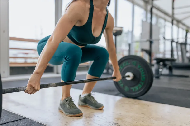 A woman setting up a deadlift